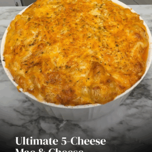 Ultimate 5-cheese mac and cheese in a white baking dish with a bubbly golden cheese crust on a marble countertop.